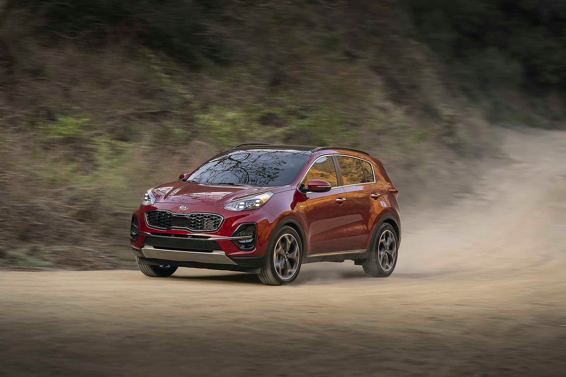 vue latérale avant du Kia Sportage 2022 roulant sur un sentier de terre