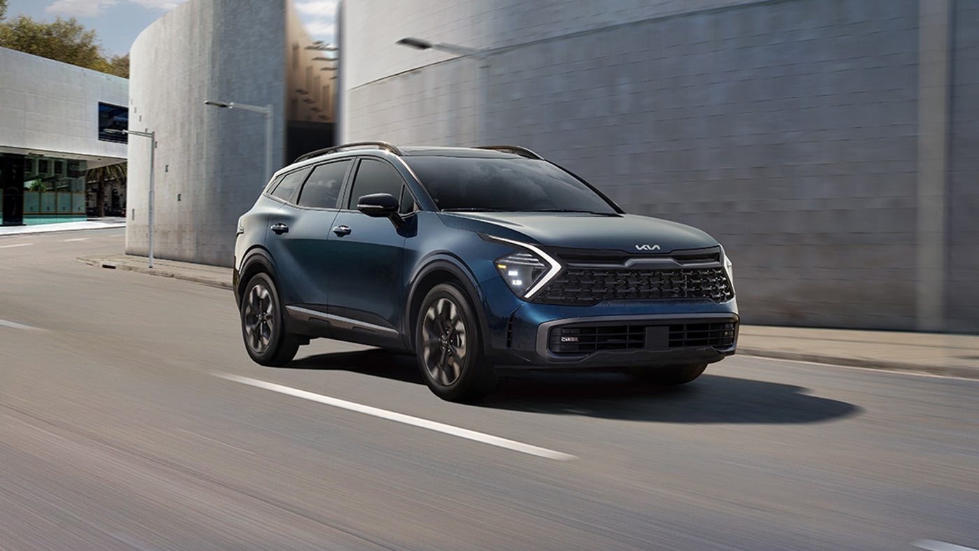 Vue 3/4 avant du Kia Sportage 2025 sur une route en ville.
